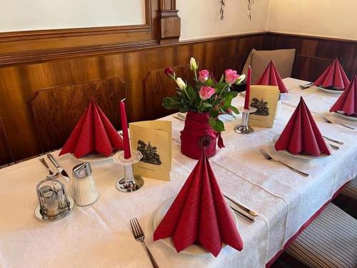 格明德Hotel Gasthof Kohlmayr的一张桌子上放着红色的餐巾和鲜花