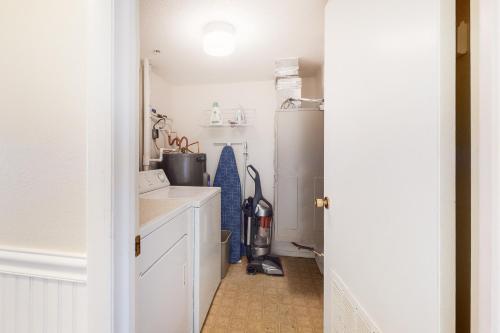 大洋城Sandpiper Dunes 105的厨房配有白色橱柜和冰箱。