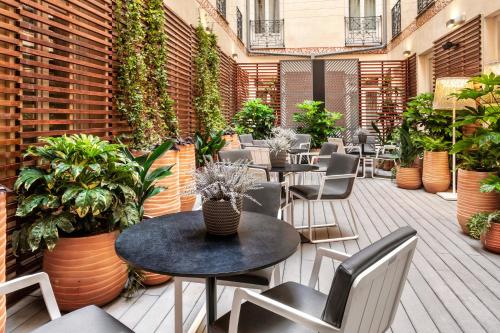 马德里梅耶广场加泰罗尼亚酒店的户外庭院设有桌椅和植物