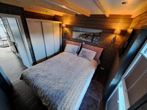 汉德维特Tiny House Flensburg Lee的卧室配有木墙内的一张床