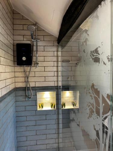 诺斯阿勒顿Elm Cottage的墙上设有带灯的淋浴的浴室