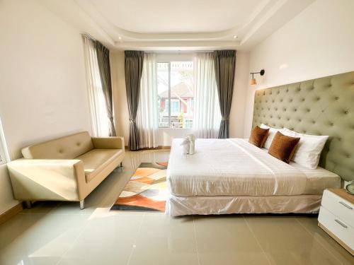 Ban Nam ChamHappy Land Residence的一间卧室配有一张大床和一把椅子