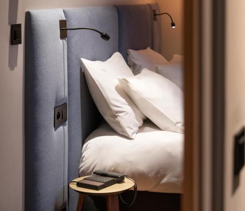 安锡Hébé Hotel的卧室配有带白色枕头和桌子的床