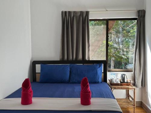 瓜隆岛快乐大象简易别墅酒店的一间卧室配有蓝色的床和红色枕头