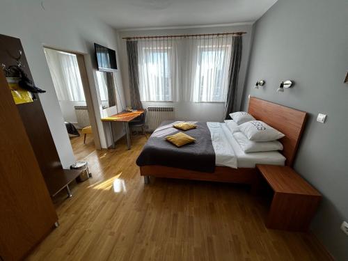斯拉沃尼亚布罗德布罗德摩托俱乐部宾馆的一间卧室配有一张床和一张书桌