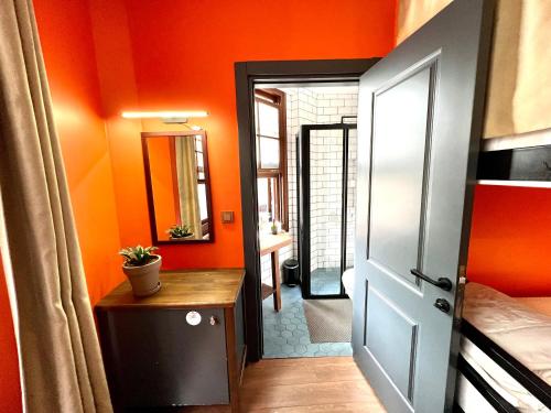 伊斯坦布尔Hostel Le Banc的一间拥有橙色墙壁、门和桌子的房间