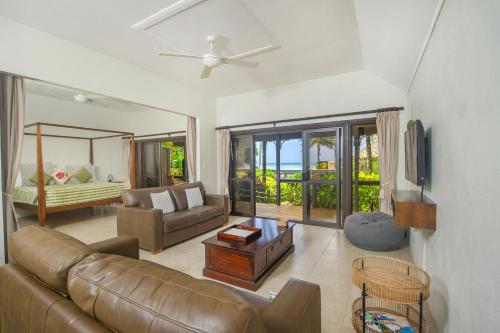 拉罗汤加海变别墅的客厅配有真皮沙发和电视