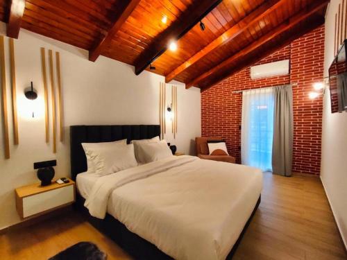 卡兰巴卡Centro Urban Suites的卧室配有白色的床和砖墙
