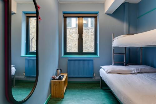 伦敦可林克261旅舍的一间拥有蓝色墙壁的卧室和一张带镜子的床
