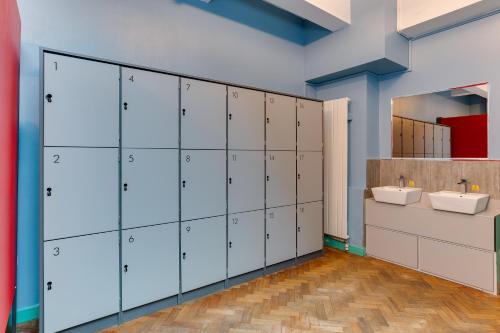伦敦可林克261旅舍的浴室设有白色储物柜和2个盥洗盆。