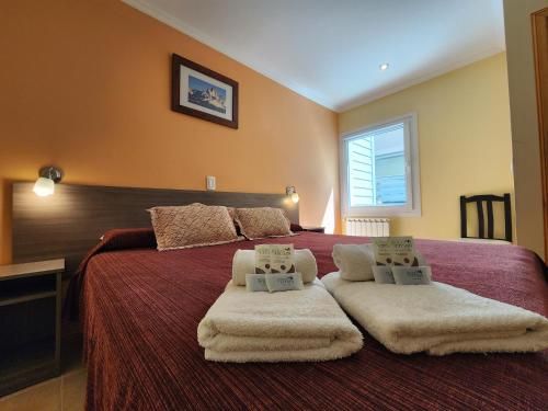 厄尔查尔坦Hostería Vertical Lodge的一间卧室配有一张大床和毛巾
