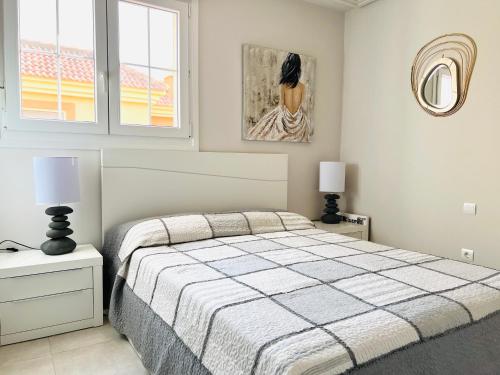 韦尔瓦Ático de lujo - Luxury Penthouse的一间卧室配有一张床、两盏灯和一幅画