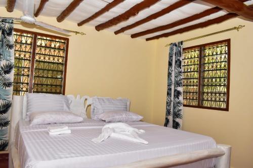 迪亚尼海滩Private room in a villa的一间卧室配有一张带白色床单和窗户的床。