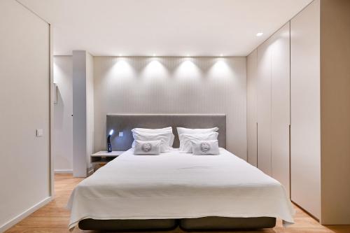 布拉加Sé Apartamentos - Sé INN Studios的卧室配有一张带两个枕头的大白色床