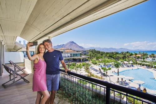 坎波菲利斯·迪·罗切Grand Palladium Sicilia Resort & Spa的站在度假胜地阳台上的男女