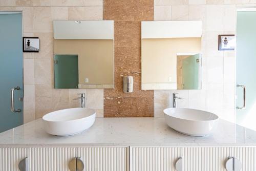 圣多明各Brickell Apart Hotel的浴室设有2个水槽和2个镜子