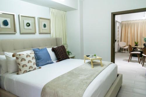 圣多明各Brickell Apart Hotel的卧室配有带蓝色枕头的大型白色床