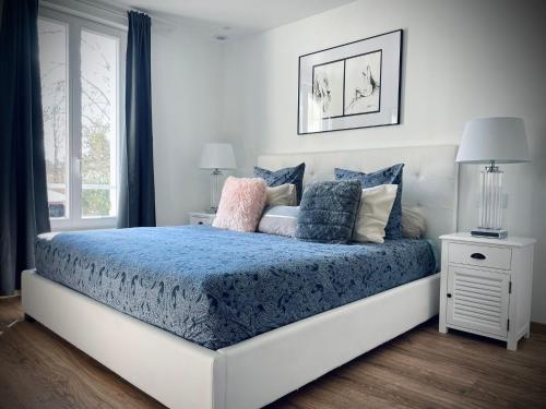 Margny-lès-CompiègneRelax & Spa - Séjour Romantique的一间卧室配有一张带蓝色床单和枕头的床。