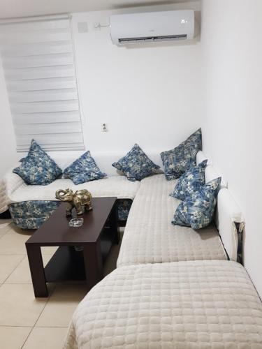莱斯科瓦茨Apartmani Strahinic的一间卧室配有两张带蓝色枕头和桌子的床