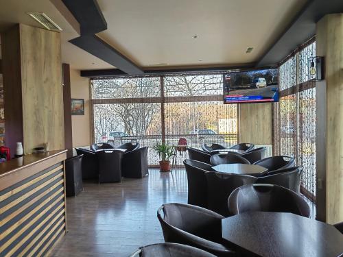 茨雷沃Family Hotel Diana的一间用餐室,配有黑色椅子和窗户