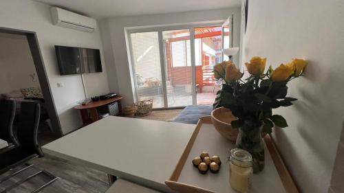 摩拉瓦托普利采Apartma Rakita的客厅配有一张桌子和黄色玫瑰花瓶
