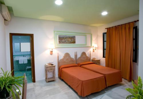 桑卢卡尔-德巴拉梅达赫雷乔斯酒店的一间卧室配有一张带橙色床罩的床