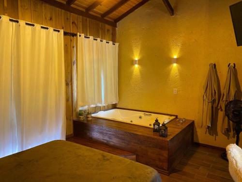 兰舒凯马杜Cabanas Recanto do Rancho - Rancho Queimado的带浴缸、床和浴缸的浴室