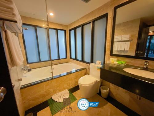 芭东海滩C & N Resort and Spa - SHA Extra Plus的带浴缸、卫生间和盥洗盆的浴室