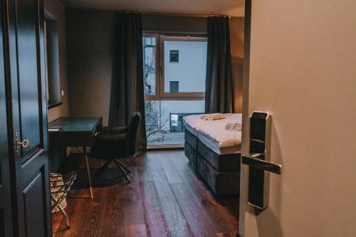 兰茨胡特LA vie Hotel Landshut的一间卧室配有一张床、一张书桌和一个窗户。