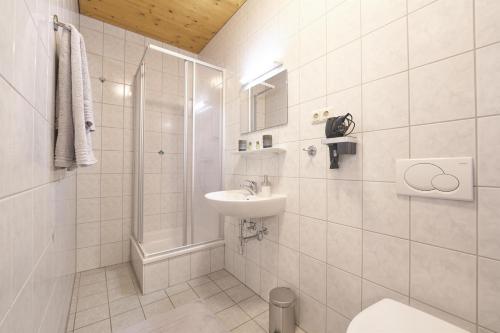 阿德蒙特Xeis NeSt的白色的浴室设有水槽和淋浴。