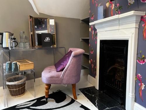 戈灵曼斯菲尔德的磨坊主酒店的带壁炉的客厅内的紫色椅子