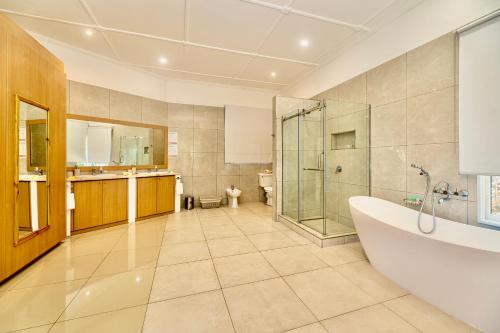 博瓦隆Luxurious 2-Bed Villa in Bel Ombre Mahe Seychelles的带浴缸、淋浴和盥洗盆的浴室