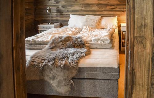 康斯博Gorgeous Home In Kongsberg With Sauna的狗躺在卧室的床上