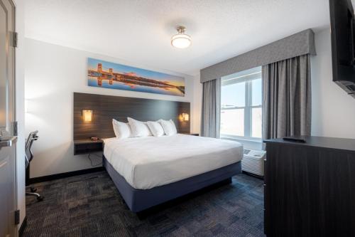 霍顿Independence Stay Hotel and Long term suites的酒店客房设有一张床和一个大窗户