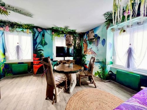 贝尔福Avataar - L'arbre de Pandoraa的一间设有桌子的用餐室,位于一间铺有热带壁纸的房间