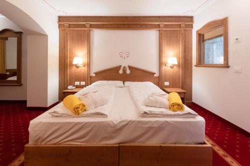 莫埃纳Hotel Fanes Suite & Spa的卧室配有一张带黄色枕头的大型白色床。