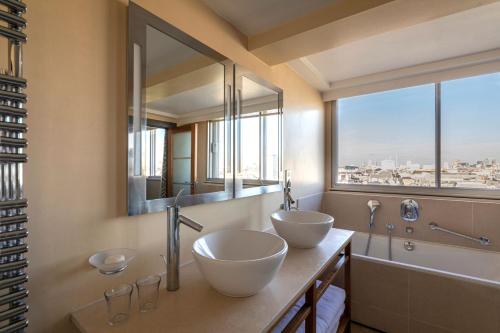 伦敦卡文迪什伦敦酒店的带大窗户的浴室内的2个盥洗盆