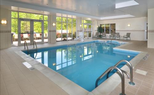 莫里斯维尔罗利达勒姆机场假日酒店的大楼内一个蓝色的大型游泳池
