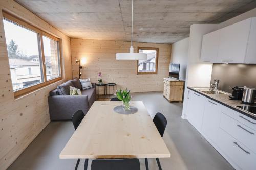 卢斯特瑙BOUTIQUE APARTMENTS LUSTENAU Nachhaltige Kühlung über Erdsonde und Fussbodenkühlung的一间厨房和客厅,客厅内配有桌子