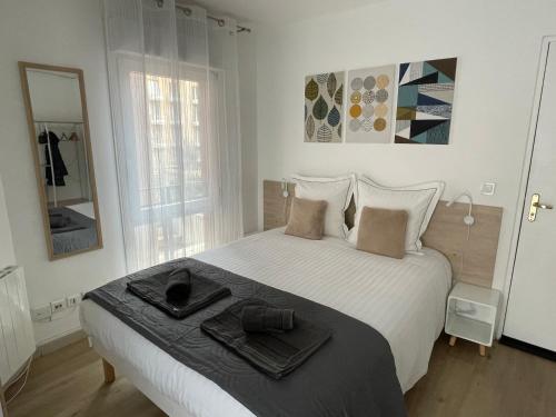普罗旺斯艾克斯Aix Homes "Les Allées Provençales"的白色卧室配有一张大床和毛巾