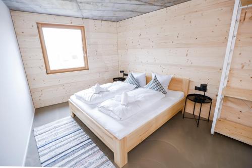 卢斯特瑙BOUTIQUE APARTMENTS LUSTENAU Nachhaltige Kühlung über Erdsonde und Fussbodenkühlung的木制客房内的一间卧室,配有一张床