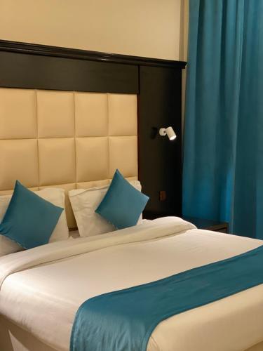 艾卜哈Samaa Eva Resort的一间卧室配有一张带蓝色枕头的大床
