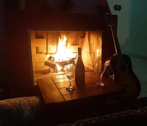 圣若泽杜斯坎普斯CASA DE CAMPO DOS SONHOS的壁炉,配有两杯酒和吉他