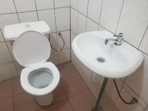 OuidahMaison fleurie Ouidah的浴室配有白色卫生间和盥洗盆。