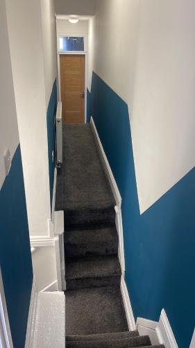 利物浦Anfield accomodation的走廊上设有蓝色墙壁和门