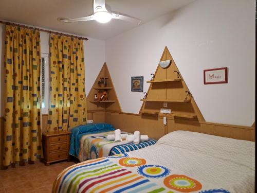 FrailesAlojamiento Árdales的一间卧室配有两张床和金字塔头