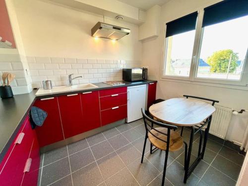 凯恩Giena - SILS的厨房配有红色橱柜和木桌