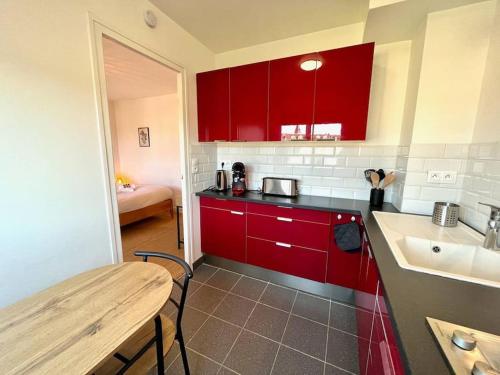 凯恩Giena - SILS的厨房配有红色橱柜、桌子和水槽