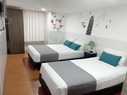 波哥大Casa Hotel Quinta Real的酒店客房 - 带两张带蓝色枕头的床