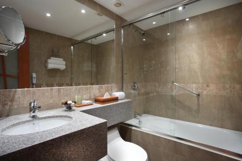 昆卡埃多拉多酒店的浴室配有水槽、淋浴和浴缸。